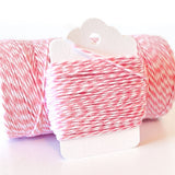 Pink and white striped bakers twine wound on a white paper hanger tag