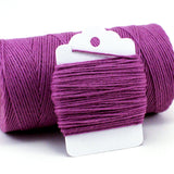 Medium purple twine wrapping around a white hang tag photographed on a clean white background.