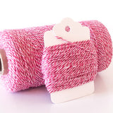 Pink, red and white twisted craft twine wrapped around a white cardstock tag.