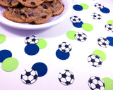 Soccer and colored confetti spread on table with plate of cookies